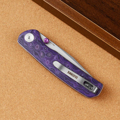 Closed OLITANS Gecko SE G080 Purple Micarta knife on a brown display surface