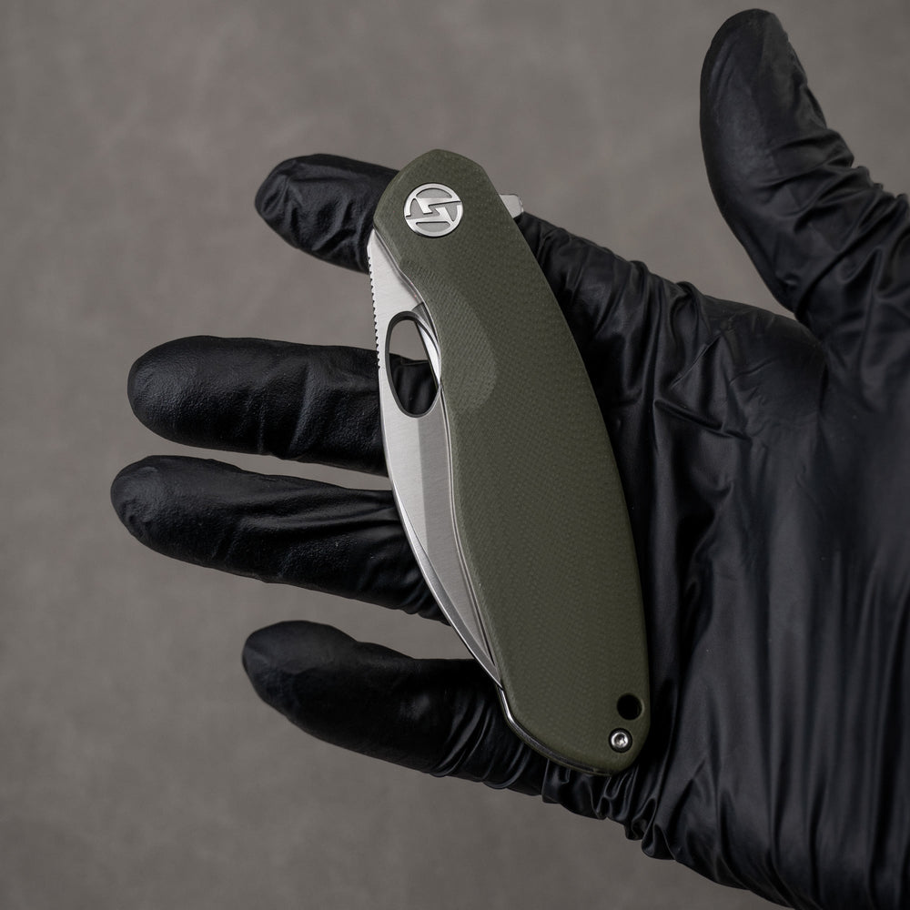 Closed G064 in hand – green handle, satin edge