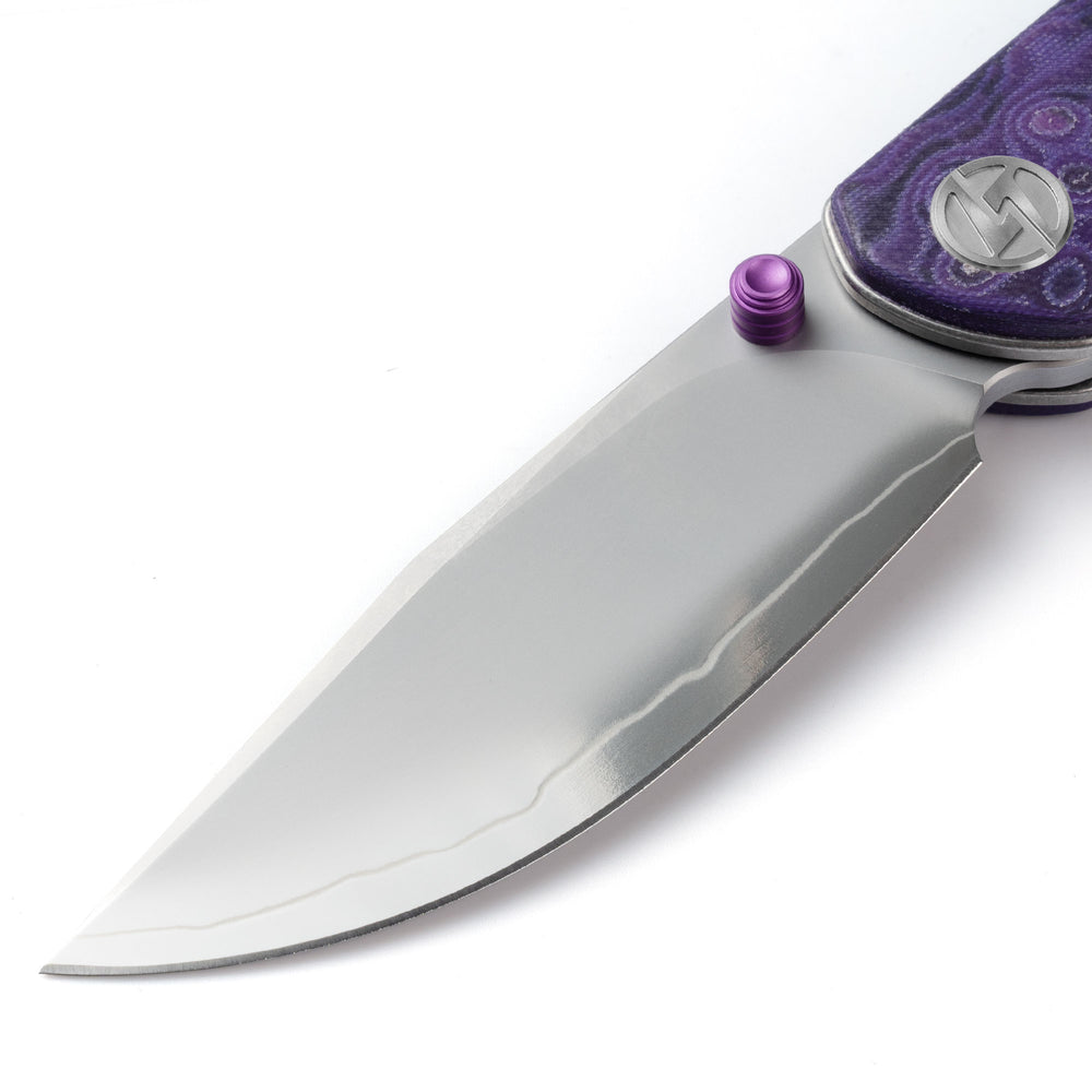 Close-up of OLITANS Gecko SE G080 gradient mirror-polished SLD-Magic drop-point blade