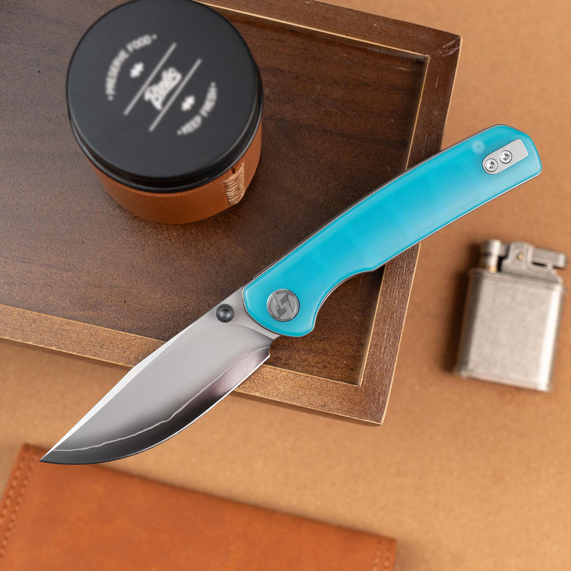 Open OLITANS Gecko SE G080 Blue Acrylic knife displayed with EDC accessories